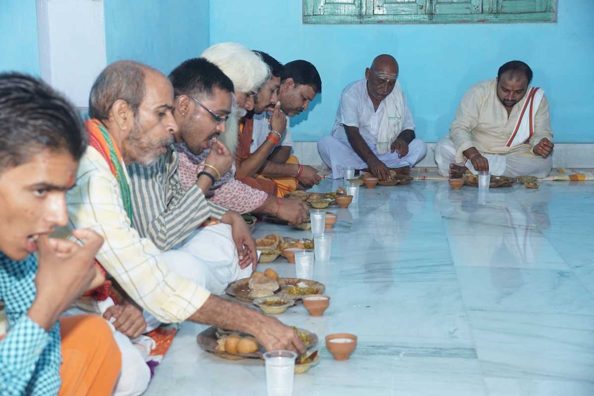 Brahmins sitting on floor and eating food after samvatsarikam ceremony in varanasi